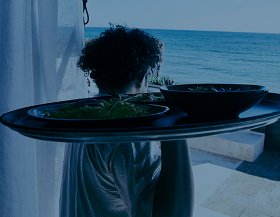 Man holding platter of food, overlooking ocean views