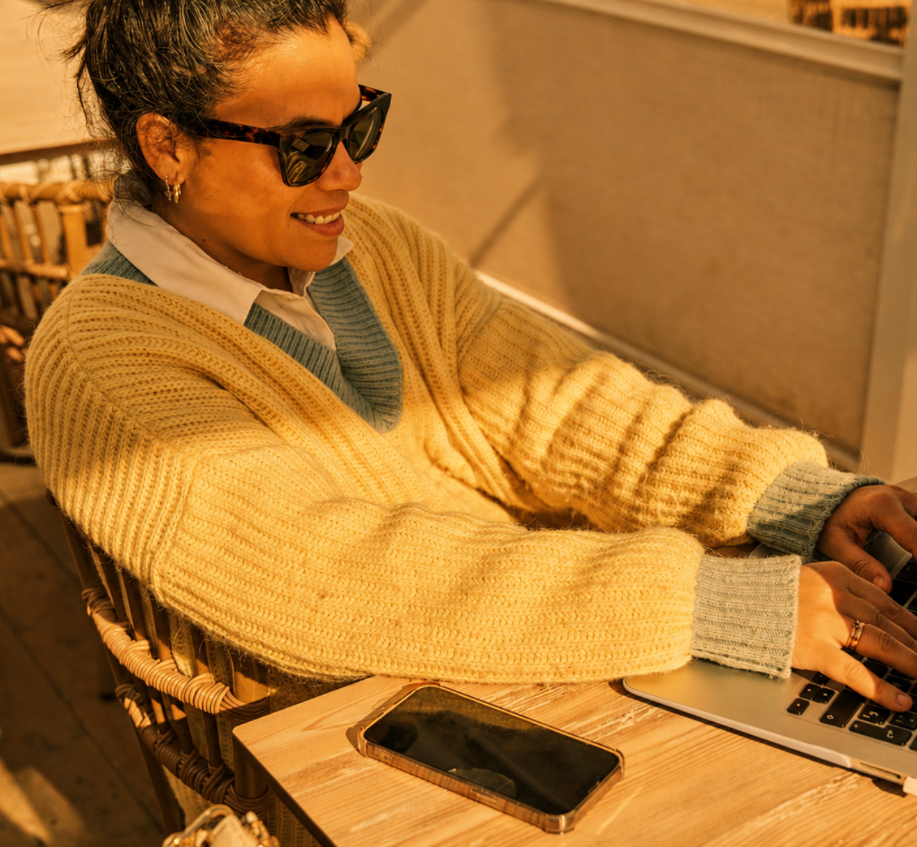 Golden-hour woman with laptop and phone