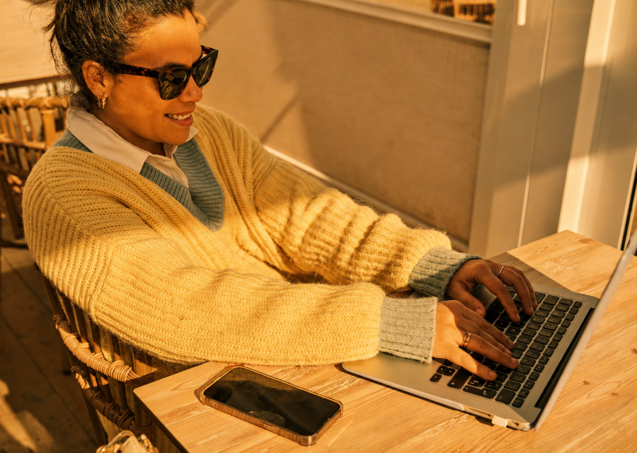 Golden-hour woman with laptop and phone
