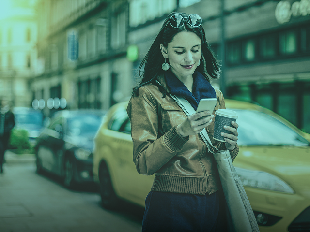 Lady drinking coffee looking at phone